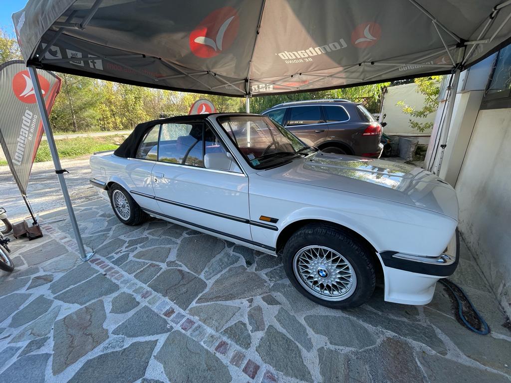 Jante BBS RZ 15 pouces montée sur BMW E30 avec cache moyeu logo BMW visible quartier avant