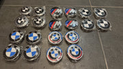 Collection insignes BMW pour caches moyeux incluant logos M Sport tricolores et BMW classiques emballés