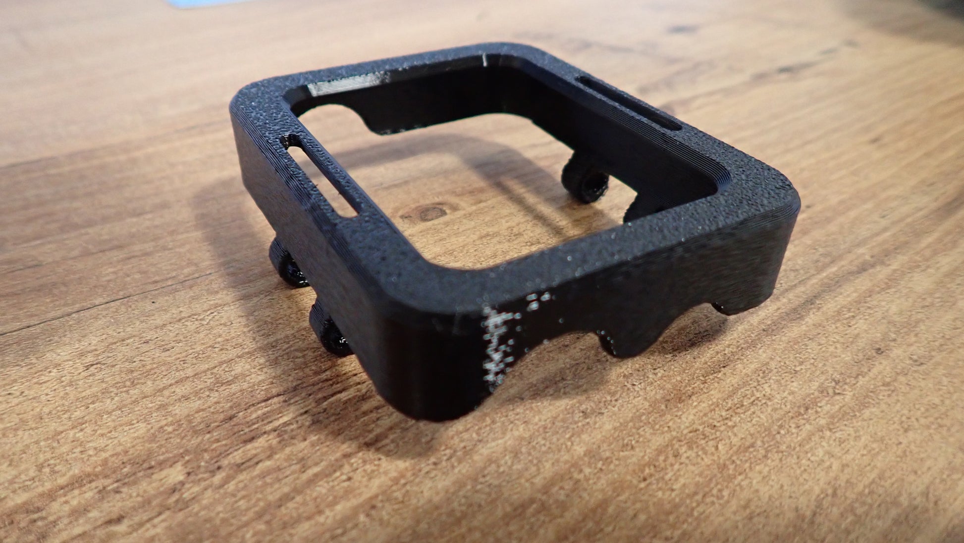 Coque protection TPU noire Shearwater Peregrine vue de côté sur table en bois