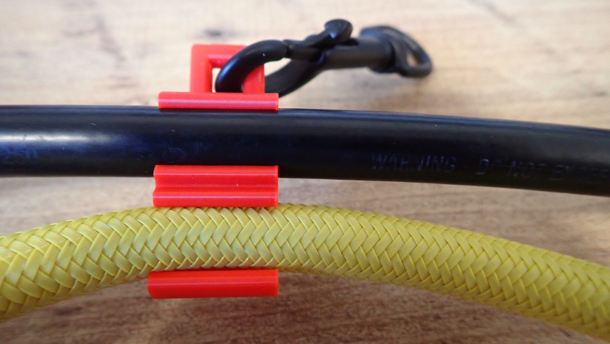 Accroche flexible plongée rouge clip détendeur octopus en situation sur flexibles