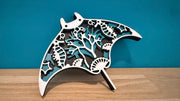 Décoration raie manta en bois blanc et turquoise posée sur une étagère