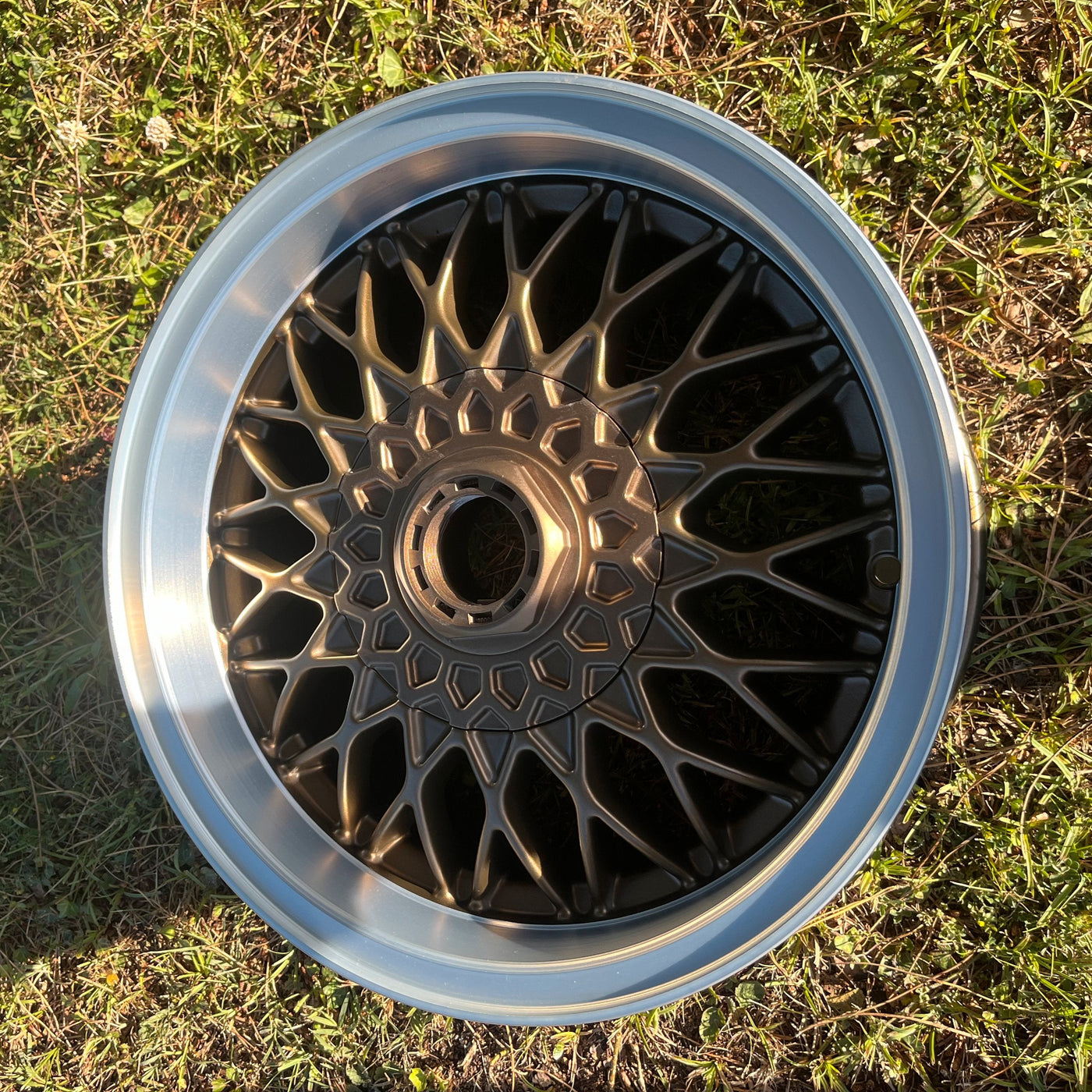 Jante BBS RZ 15 pouces bronze et argent montée sur BMW E30 avec cache moyeu central visible