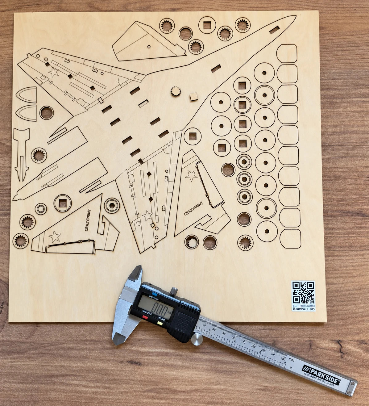 Planche de bois découpée au laser avec les pièces d'un puzzle avion et un pied à coulisse